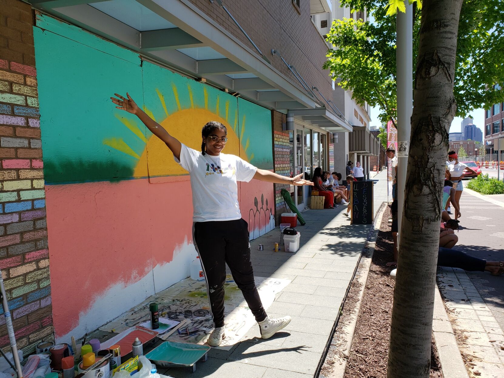 Shade Bell in front of her mural at Homespun on Mass Ave